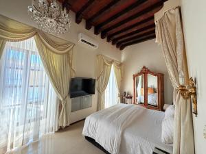 a bedroom with a bed and a mirror and windows at Ébano Hotel Boutique in Oaxaca City