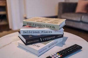 a stack of books sitting on a table next to a remote at Monthly & Weekly Offers , Pool Table , PS4 , Liverpool , 3 Bed House , Ideal For Contractors , Relocation & Family Stays in Litherland