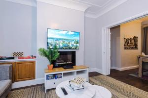 a living room with a tv on a wall at Monthly & Weekly Offers , Pool Table , PS4 , Liverpool , 3 Bed House , Ideal For Contractors , Relocation & Family Stays in Litherland