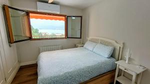a small bedroom with a bed and a window at ROYAL BEACH - Appartment with sea view & terrace in Faro de Cullera