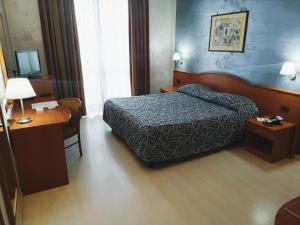 ein Hotelzimmer mit Bett und Schreibtisch in der Unterkunft Hotel Brindor in Poirino