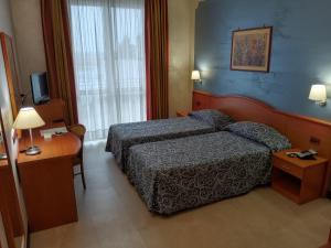 ein Hotelzimmer mit Bett und Schreibtisch in der Unterkunft Hotel Brindor in Poirino