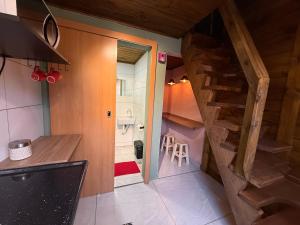 a small kitchen with a stairs leading to a bathroom at Vilarejo hospedagem- Espaço Beco Carioca in Ilha do Mel