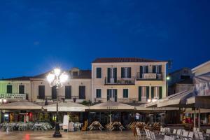 eine Straßenlaterne vor einem Gebäude mit Tischen und Stühlen in der Unterkunft Hotel Patrai in Lefkada Town