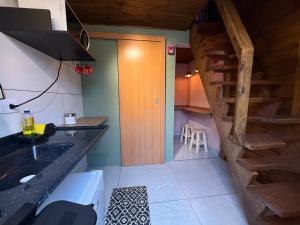 a kitchen with a sink and a wooden staircase at Vilarejo hospedagem- Espaço Beco Carioca in Ilha do Mel +13 photos