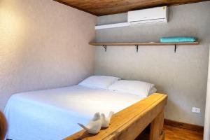 a bedroom with a bed with white shoes on it at Vilarejo hospedagem- Espaço Beco Carioca in Ilha do Mel