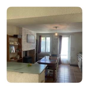 a kitchen with a table and a dining room at Chambre dans Maison de campagne in Barbaste
