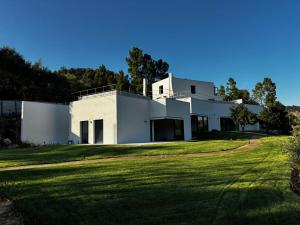 a white house on a grassy field at Casa Calmavista in Paços de Gaiolo