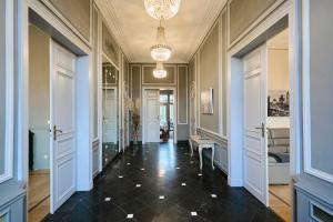 a hallway with doors and a chandelier in a building at Le Château des Comtesses - Vue lac, 13 pers in Montignies-sur-Roc