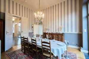 a dining room with a table with chairs and a chandelier at Le Château des Comtesses - Vue lac, 13 pers in Montignies-sur-Roc +47 photos