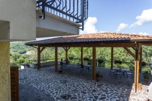 einen Pavillon mit Tischen und Stühlen auf einer Terrasse in der Unterkunft B&B Le Ginestre in Viggianello