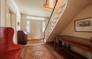 a living room with a staircase and a table at Oak & Anchor Inn in Penn Yan +15 photos