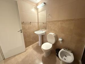 a bathroom with a toilet and a sink at Hotel Haití in San Miguel de Tucumán +27 photos