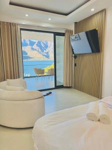 a hotel room with a bed and a flat screen tv at TOKIO - Apartamentos by Luxury Atitlan in San Pedro La Laguna