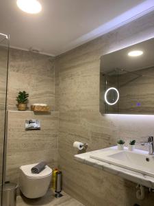 a bathroom with a sink and a toilet and a mirror at Garibaldi in Ioannina +23 photos