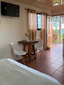 a bedroom with a table and two chairs and a television at Magic Lodge - Cirrí, Naranjo in Cirrí