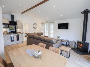 a living room with a couch and a table with a fireplace at Lakeside Lodge in Preston
