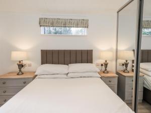 a bedroom with a large white bed and mirrors at Lakeside Lodge in Preston