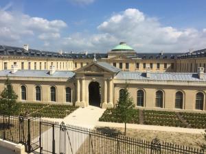 a large building with a fence in front of it at Hotel des Lys in Versailles