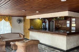 a bar with a couch and chairs in a room at Hotel Santa Barbara in Arauca