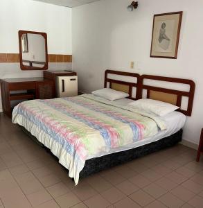 a bedroom with a bed with a mirror and a dresser at Hotel Santa Barbara in Arauca