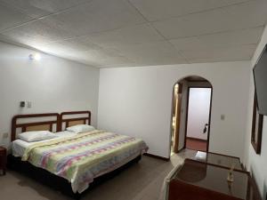 a bedroom with a bed and an open doorway at Hotel Santa Barbara in Arauca