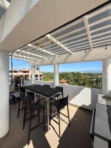 a patio with a table and chairs on a balcony at Ideal beach getaway in Nenúfares 2-101 in Nuevo Vallarta