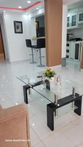 a living room with a glass table and a piano at Obynb in Santo Domingo +35 photos