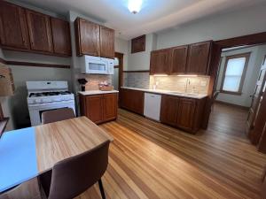 a kitchen with wooden cabinets and a wooden floor at Casa Lentini in Omaha +18 photos