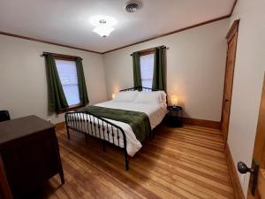 a bedroom with a bed and two windows at Casa Lentini in Omaha