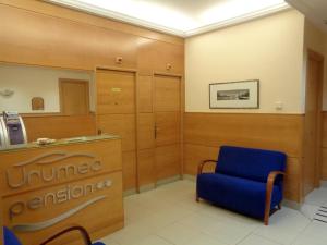 a waiting room with a blue chair and a sign at Pensión Urumea in San Sebastián