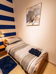 a bedroom with a bed and a painting on the wall at Cobalt Canopy a Spacious 2 Bedroom Apartment in St. Paul's Bay +9 photos