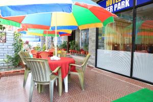 a table with chairs and a colorful umbrella at Hotel River Park in Pokhara