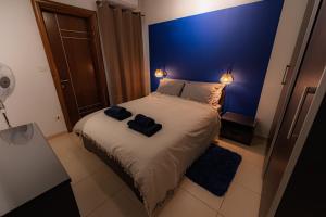 a bedroom with a large bed with a blue wall at Cobalt Canopy a Spacious 2 Bedroom Apartment in St. Paul's Bay