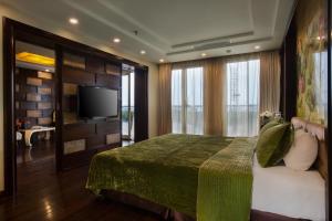 a bedroom with a bed and a flat screen tv at Golden Silk Boutique Hotel in Hanoi