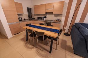 a kitchen with a table and chairs and a couch at Cobalt Canopy a Spacious 2 Bedroom Apartment in St. Paul's Bay