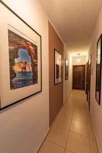 a hallway with paintings on the walls at Cobalt Canopy a Spacious 2 Bedroom Apartment in St. Paul's Bay