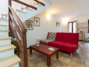 a living room with a red couch and a table at Apartment Rote Rose by Interhome in Brusasco