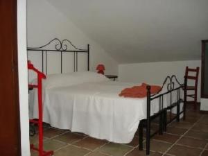 a bedroom with a bed with a white blanket and two chairs at Apartment Rote Rose by Interhome in Brusasco