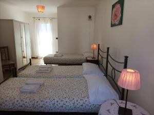 a bedroom with two beds and a lamp and a window at Apartment Rote Rose by Interhome in Brusasco