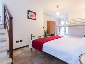 a bedroom with a bed with a red blanket at Apartment Rote Rose by Interhome in Brusasco