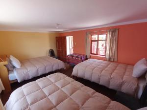 a hotel room with two beds and a window at Casa Amadeus in Estanciasuyo