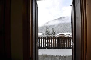 a window with a view of a snow covered mountain at P&P Home in Valdidentro +50 photos