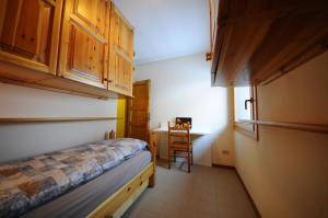 a small room with a bed and a desk at P&P Home in Valdidentro