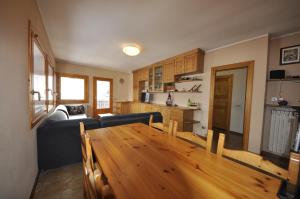 a living room with a blue couch and a wooden table at P&P Home in Valdidentro