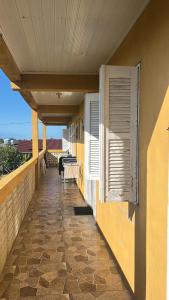 a balcony of a house with a table and windows at Pousada Mar & Sol in Torres +4 photos