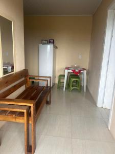 a room with a bench and a table and a refrigerator at Pousada Mar & Sol in Torres