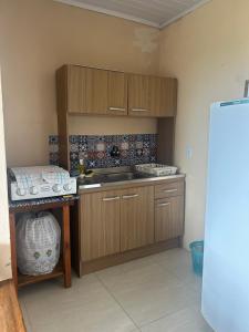 a kitchen with wooden cabinets and a sink at Pousada Mar & Sol in Torres
