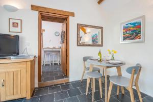 a living room with a table and chairs and a television at Y Sied in Newport