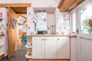 a kitchen with white cabinets and a sink at Y Sied in Newport